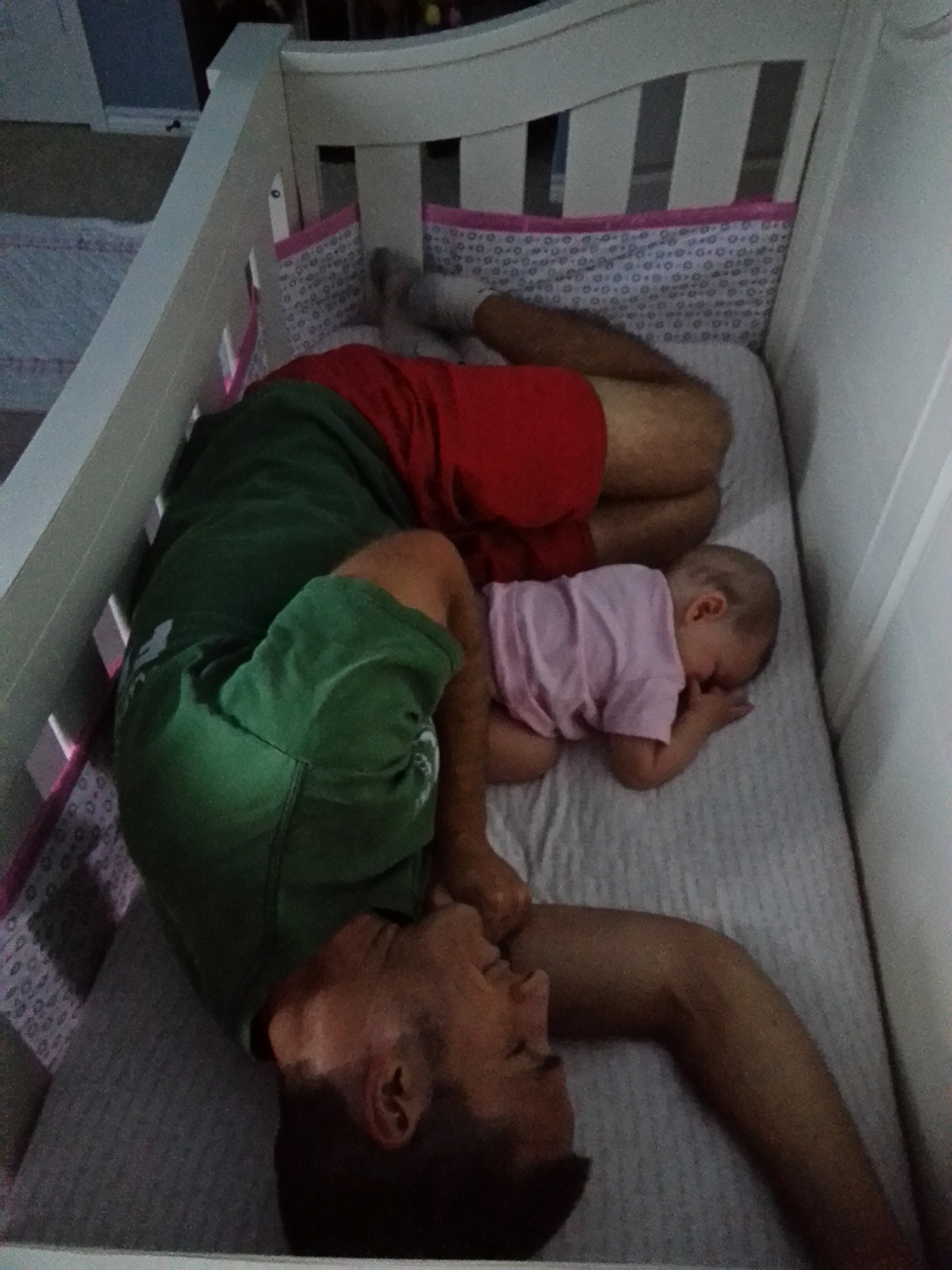 Dad asleep with Avery in crib